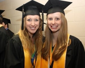 From left, Cassidy Wells and Anna Patrick, highest GPA arts and communications majors selected to carry the college of arts and communication commencement banner.