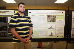 Scott Hatfield is shown with his research poster.