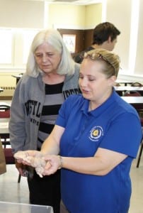 High school counselor Marilyn Wehrheim looks on as Tifani Fletcher, assistant professor of psychology demonstrates the anatomy of a sheep brain.