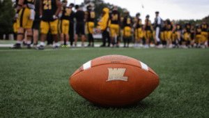 Football with players behind it