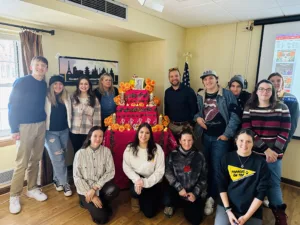 Dr. Felipe Rojas with students by the altar in the Día de Muertos presentation.