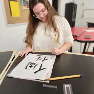  Pictured: Graduate student Serena Smith tries Japanese calligraphy at WLU.
