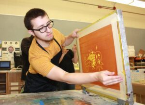 Sean Ritner works on his print.