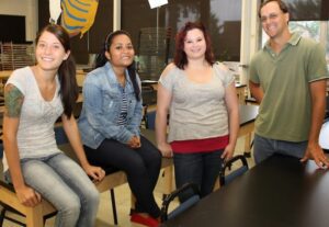 From left creative art therapy students, Megan Adams, Azia Goolie and Megan Velan, meet with Professor Brian Fencl in the art department.