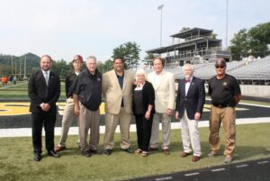 From left, Vice President of Institutional Advancement Jason Koegler, Eric Matyskiela, Athletic Director Jim Watson, Head Football Coach Roger Waialae, Flip and Gary West, Provost Brian Crawford and XXX Larry Skrzypek.