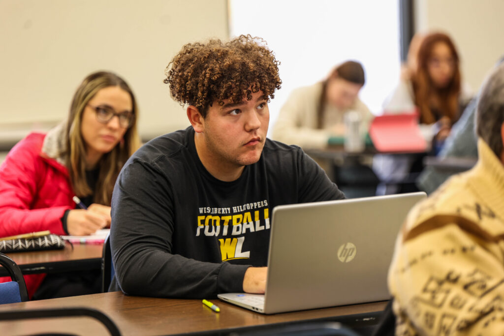 student studying with laptop in class scaled