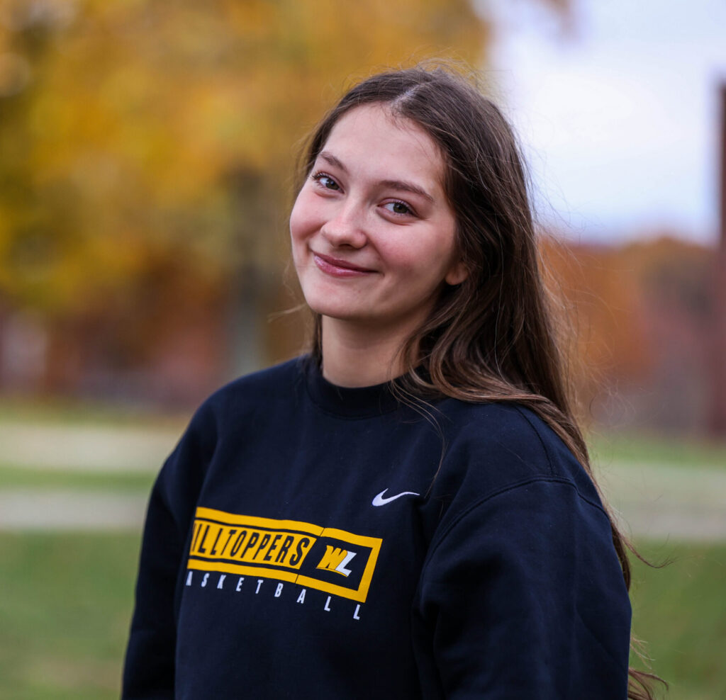 smiling student in autumn campus setting