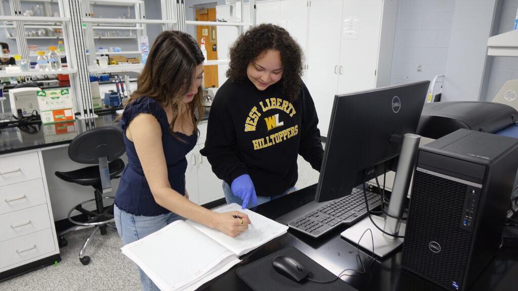 students reviewing notes at lab computer
